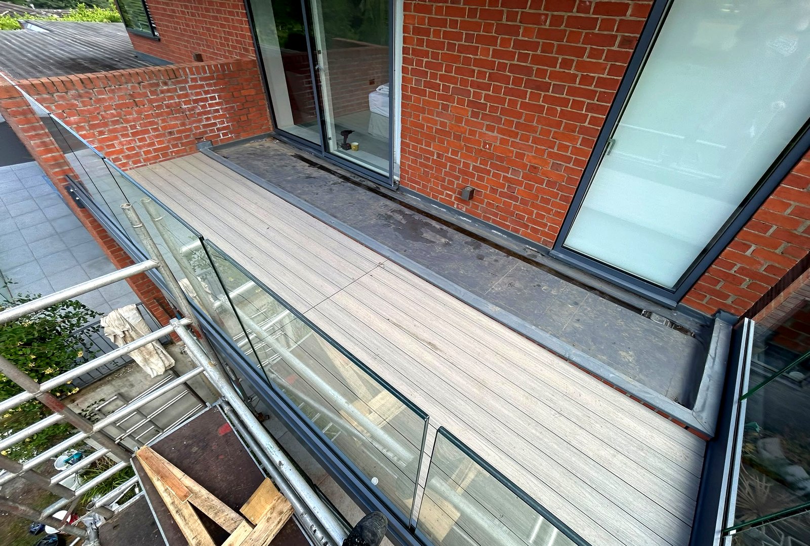 Frameless 17.5mm laminated glass balustrade along a composite-decked balcony, Buckinghamshire
